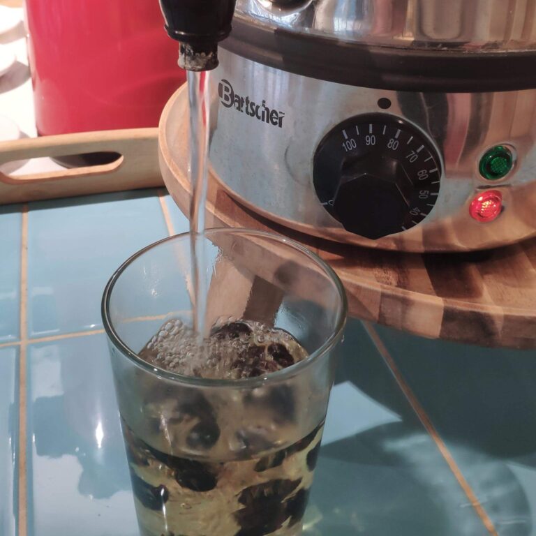 Heißes Wasser läuft über die Kaffeekirschen für Cascara Tee
