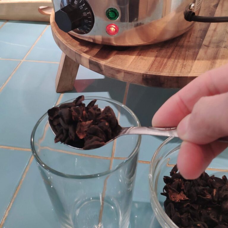Kaffeekirschen auf Löffel über Glas für Tee