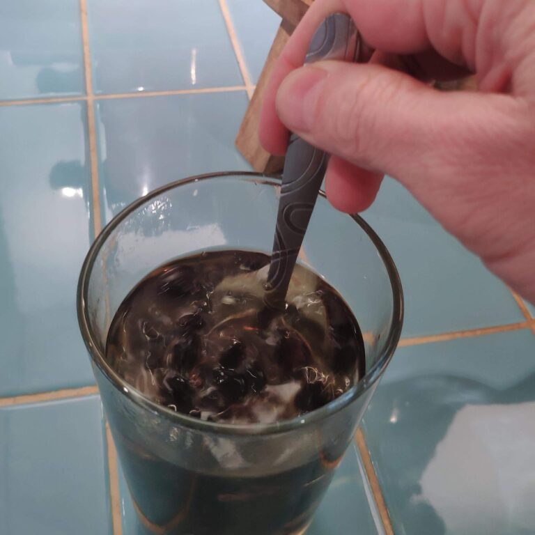 Kaffeekirschen mit heißem Wasser werde umgerührt im Glas